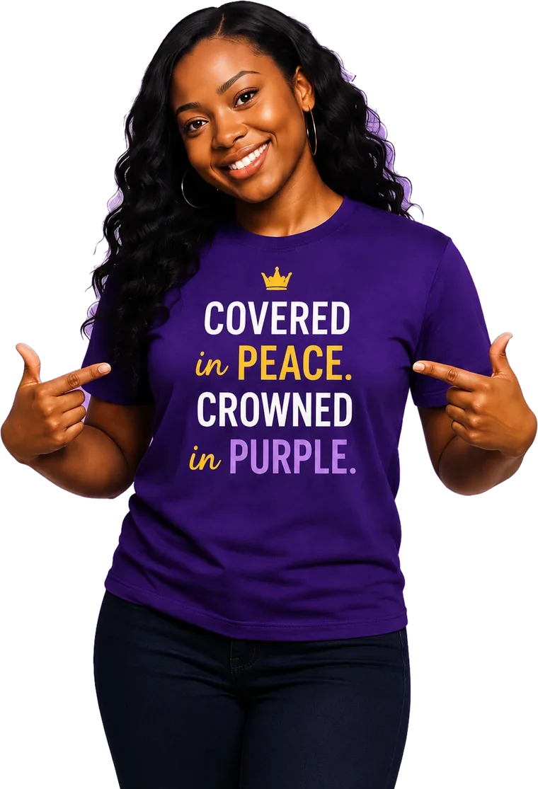 Smiling supporter pointing to her purple Epilepsy Dove t-shirt printed with "Covered in Peace. Crowned in Purple."